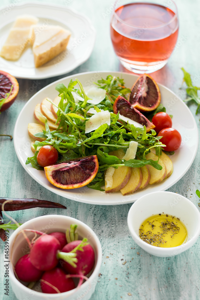 Fresh spring salad with arugula, pear and orange slices and walnuts on wooden table. Selective focus Fresh spring salad with arugula, pear and orange slices and walnuts on wooden table. Selective focus