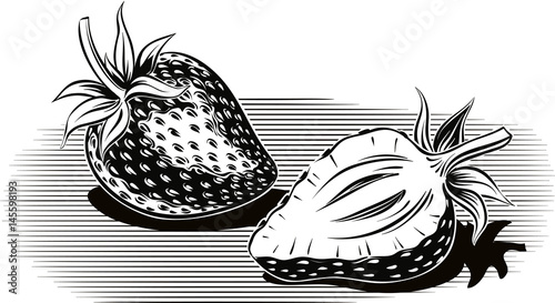 Two ripe strawberries, one cut in half.