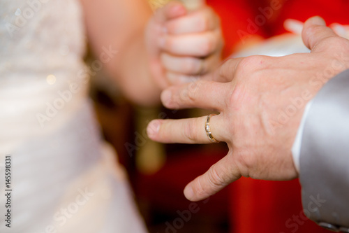 Close up hands of bride and groom putting on a wedding rings