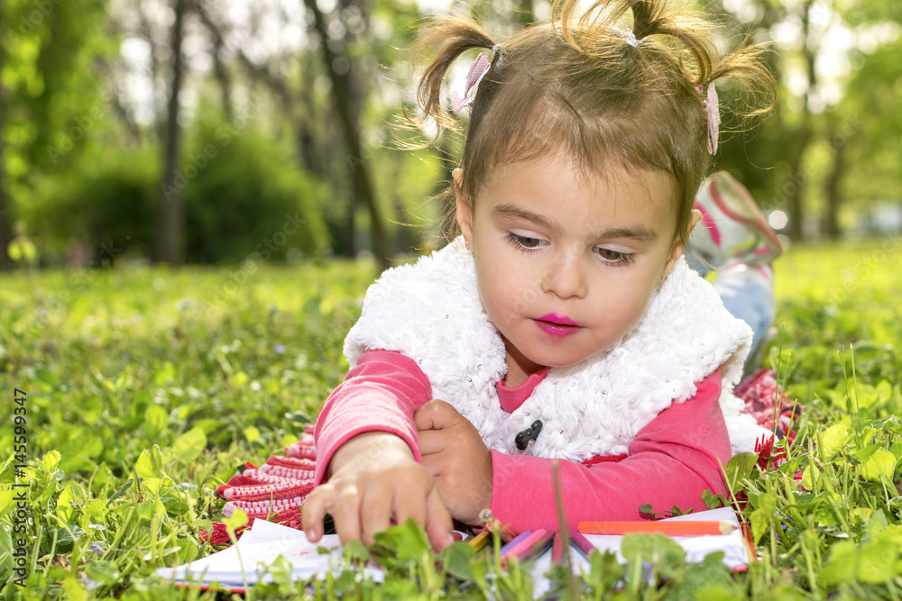 The little girl draws in nature The little girl draws in nature