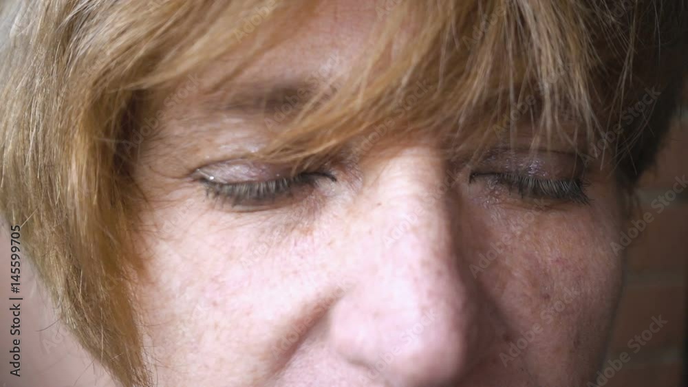 sad mature woman'sblue eyes slowly open- slow motion sad mature woman'sblue eyes slowly open- slow motion