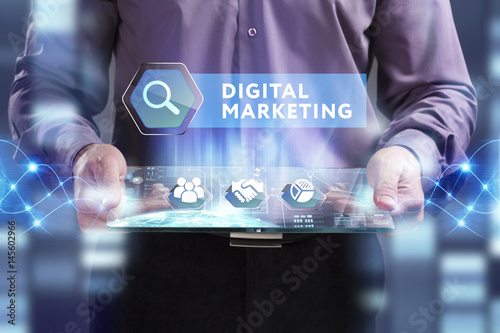 Business, Technology, Internet and network concept. Young businessman working on a virtual screen of the future and sees the inscription: Digital Marketing