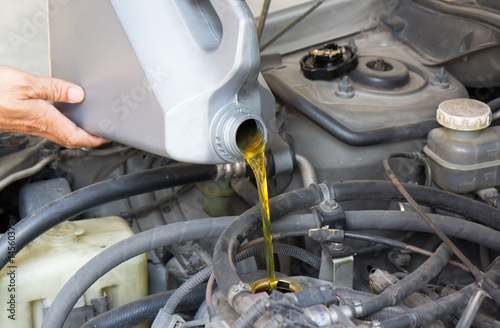 pouring motor oil to car engine, concept : service and maintenance for old car