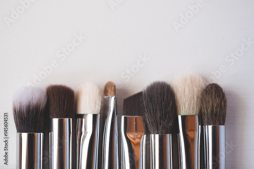 Makeup brushes on wooden background.
