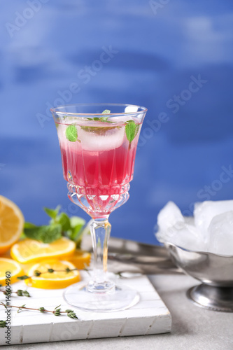 Glass of delicious wine spritzer on color background