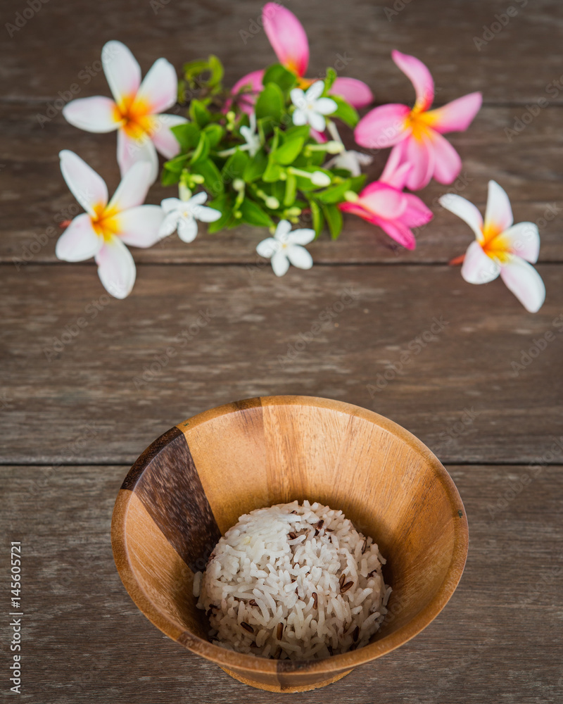 cooked rice in wood bowl and flower on table cooked rice in wood bowl and flower on table