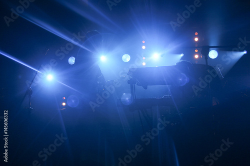 Concert lights on bright stage lights with up Laser rays on the blue background