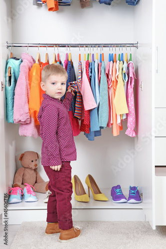Cute small boy choosing clo...