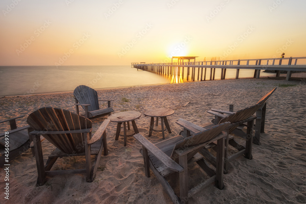 Wooden table beach front. Group of a chair and wooden table beach front in public area with warm sunshine. relax time