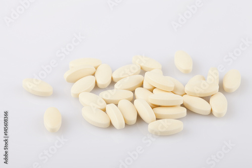 Yellow pills on a white surface. Pills isolated on white background.