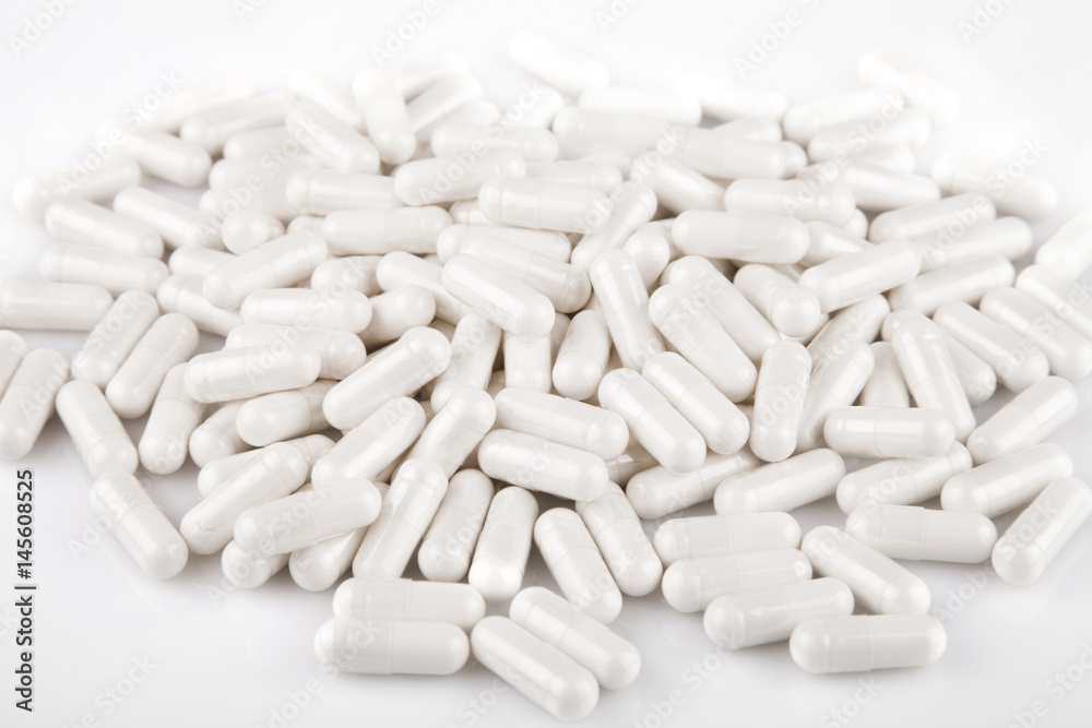 Glucosamine caplets on a white surface. Caplets isolated on white background. Glucosamine caplets on a white surface. Caplets isolated on white background.