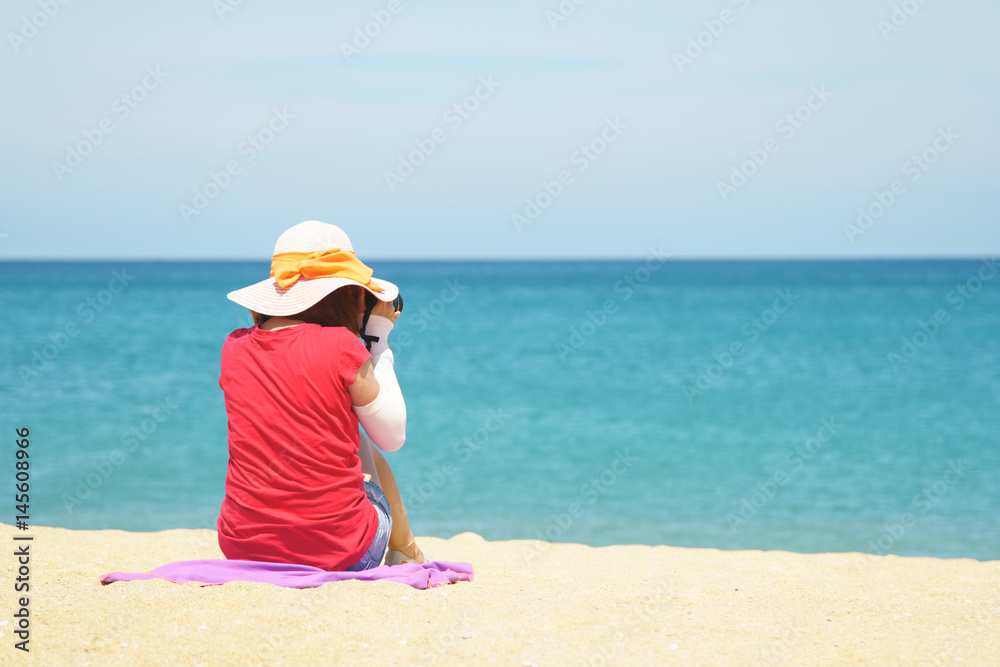lady sitting on beach and taking photo, dressing sun protection suit lady sitting on beach and taking photo, dressing sun protection suit