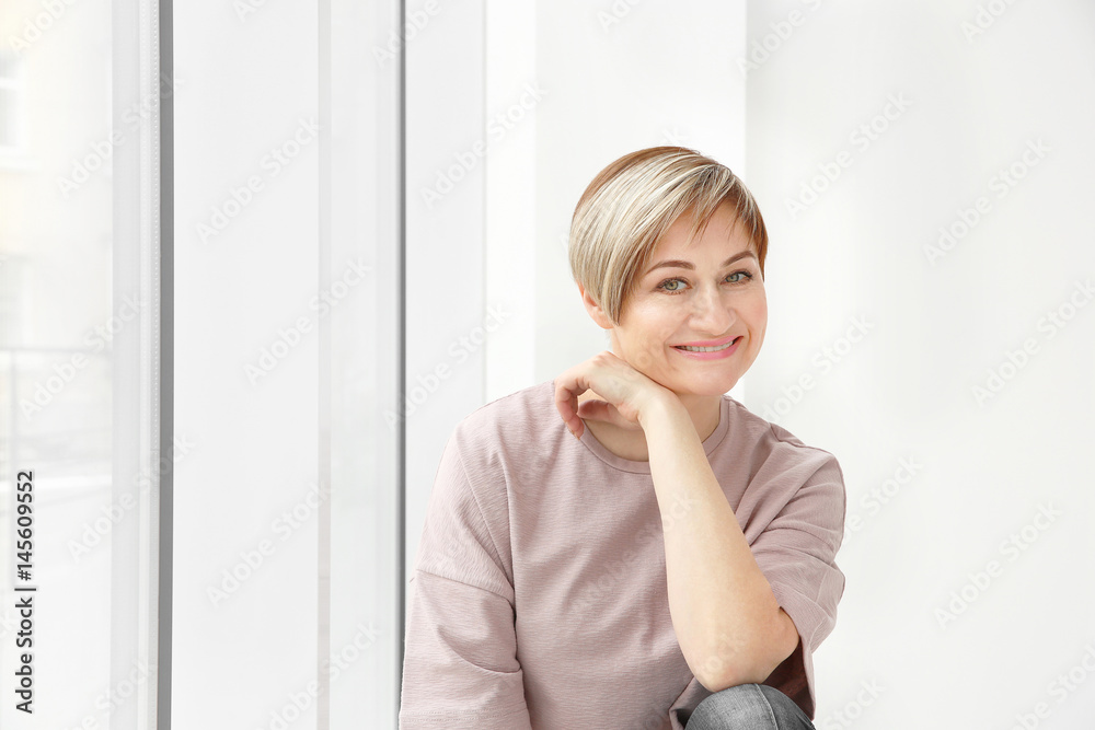 Beautiful mature woman near window at home Beautiful mature woman near window at home