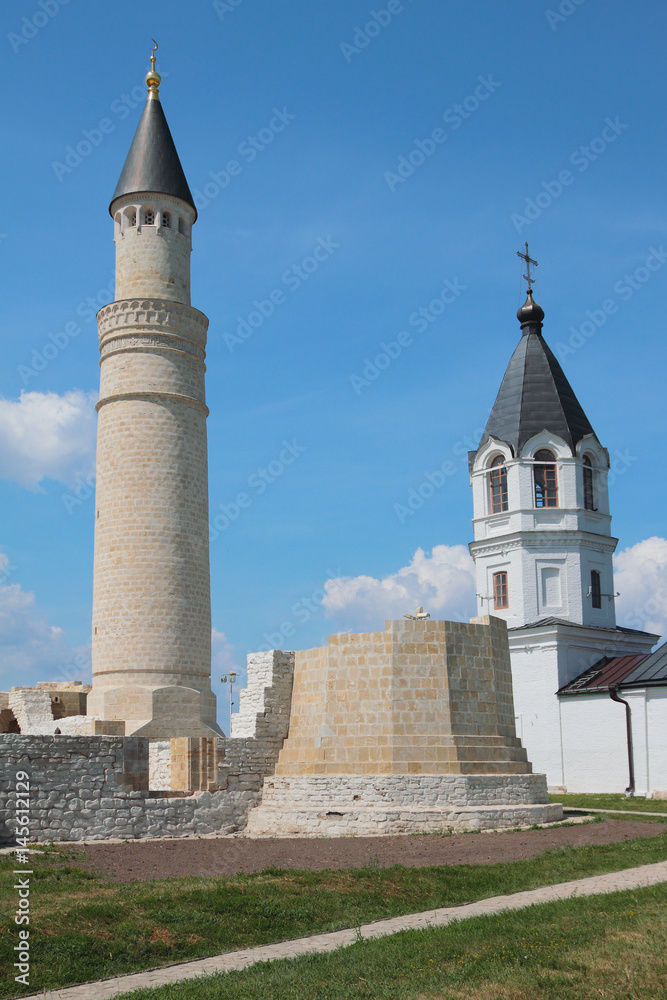 Fototapeta premium Minaret of Cathedral mosque and belltower of Church of Assumption. Bulgar, Russia