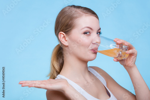 Woman drinking orange flavored drink or juice