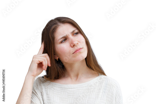 Portrait of a young brunette woman in a light jumper with a thoughtful expression looking away isolated on white background. Demonstration of various emotions.