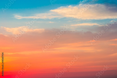 Beautiful dramatic sunset sky with red orange pink purple colors and birds. Natural background