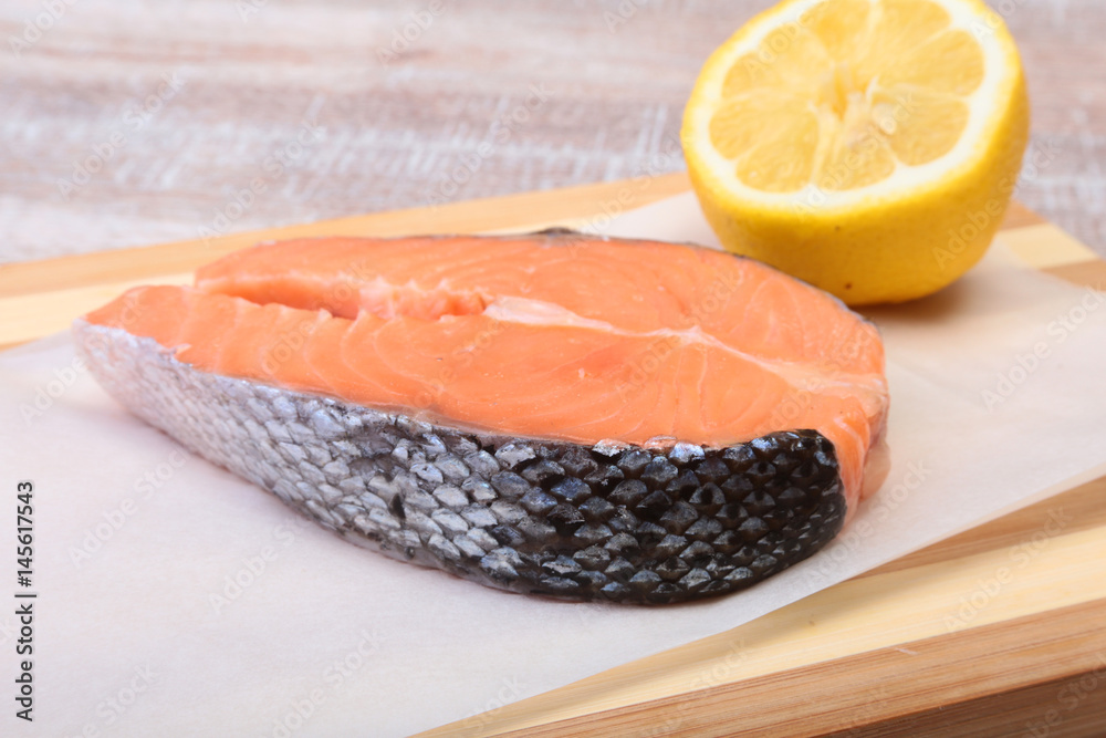 fresh raw salmon with spices and lemon on wooden cutting board. ready for cookin fresh raw salmon with spices and lemon on wooden cutting board. ready for cookin