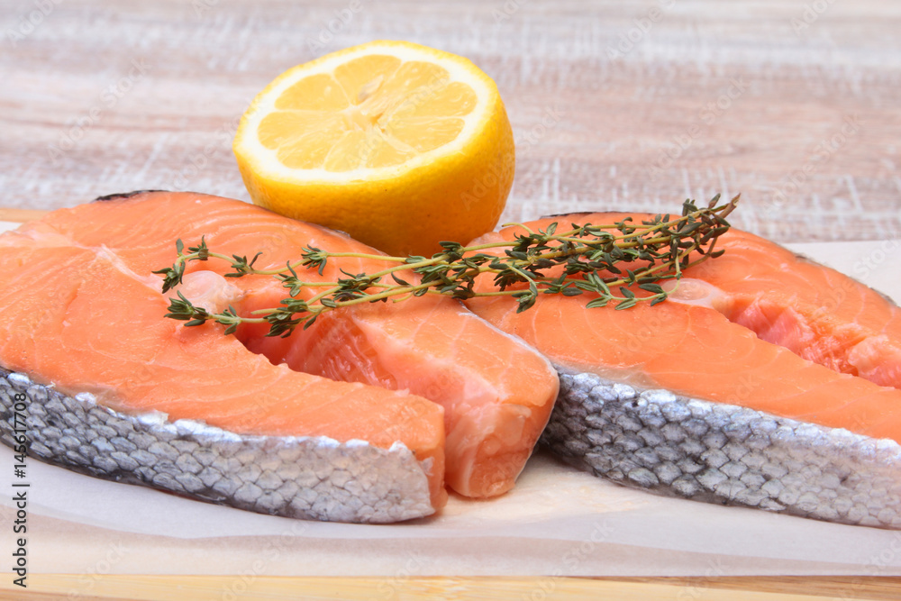 fresh raw salmon with spices and lemon on wooden cutting board. ready for cookin fresh raw salmon with spices and lemon on wooden cutting board. ready for cookin