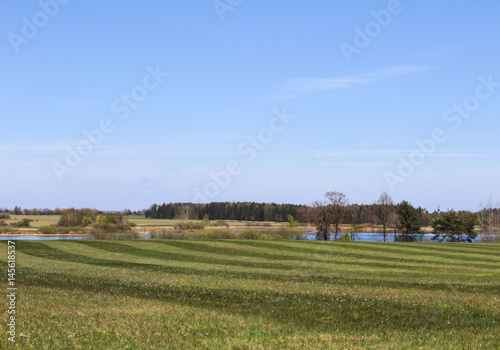 Big grass field with pond in background. Czech landscape.