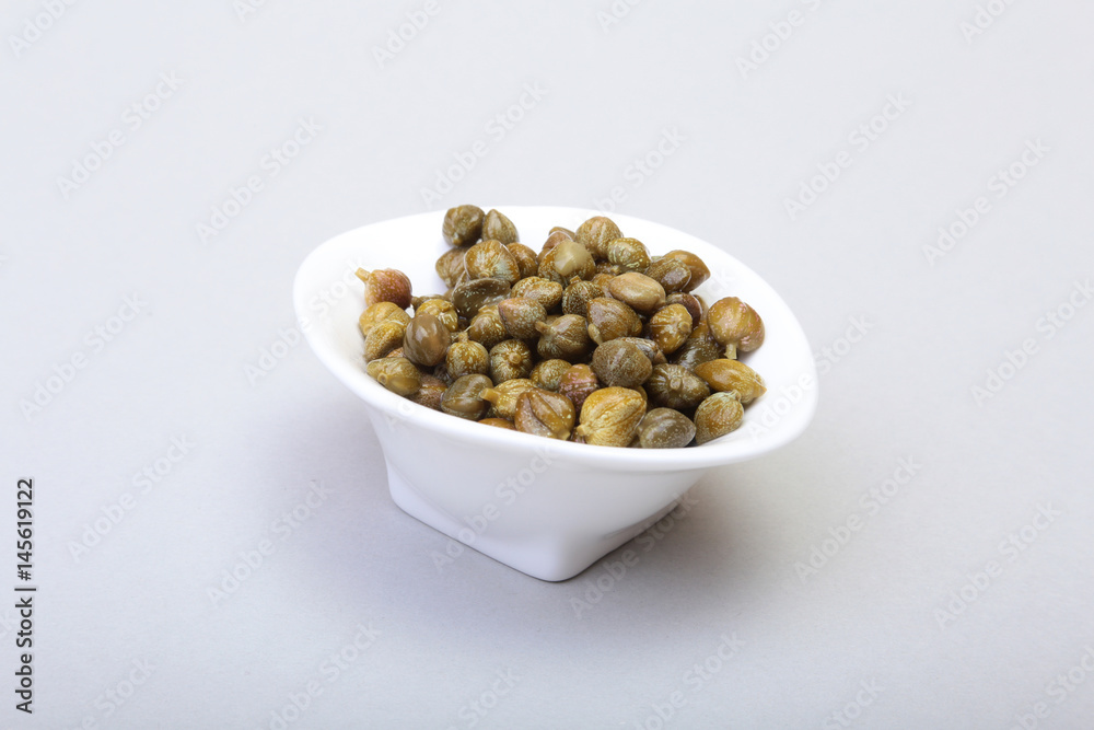 bowl with fresh capers isolated on white background. bowl with fresh capers isolated on white background.