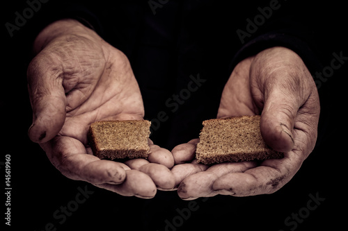 Dirty hands of a man clamped a piece of bread.