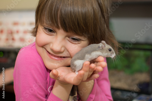 Little girl playing with hamster