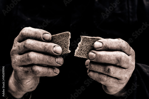 Dirty hands of a man clamped a piece of bread.

