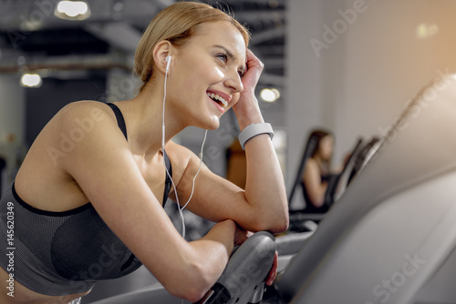 Outgoing female listening music in fitness center © Yakobchuk Olena