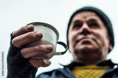 Fotografie The hand of man clamped a metal Cup.