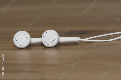 Closeup Of White Earphones On Wooden Background