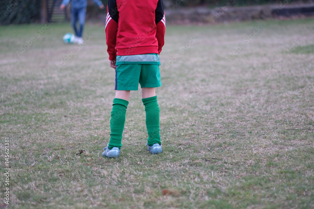 Fototapeta premium Boys playing football on the playground near the house