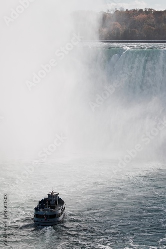 Beautiful background with amazing Niagara waterfall and a ship in the mist