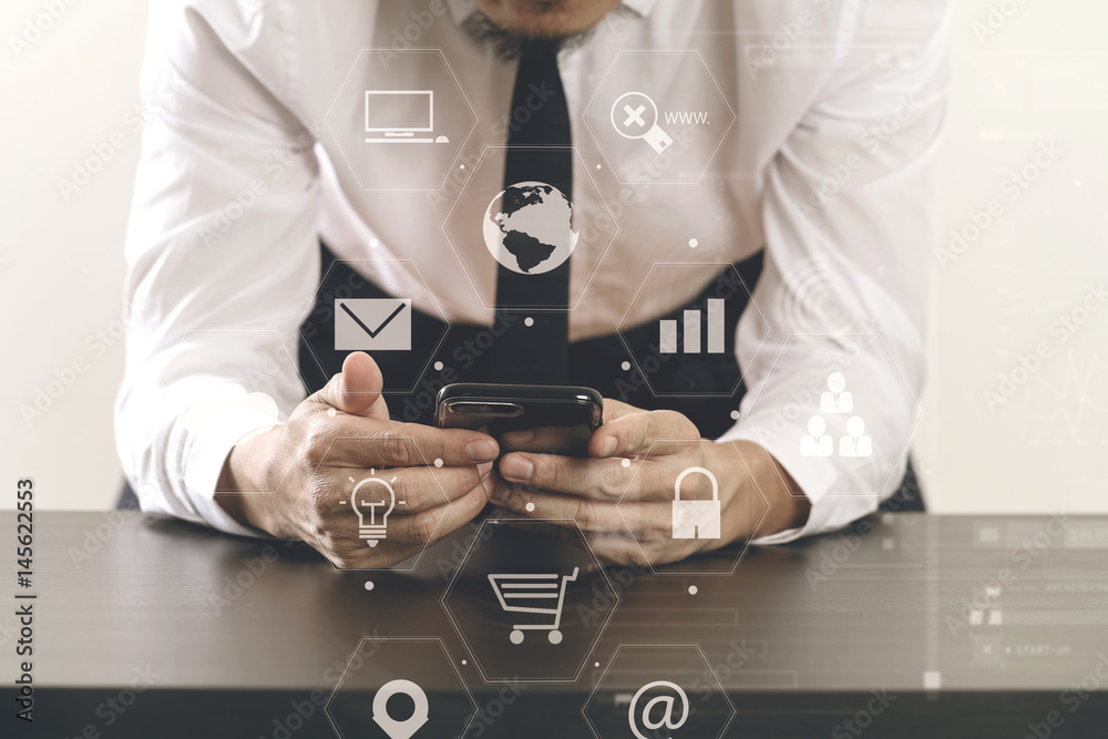 close up of businessman working with smart phone on wooden desk in modern office with virtual icon diagram close up of businessman working with smart phone on wooden desk in modern office with virtual icon diagram