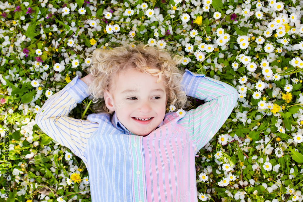 Child on green grass lawn with summer flowers Child on green grass lawn with summer flowers