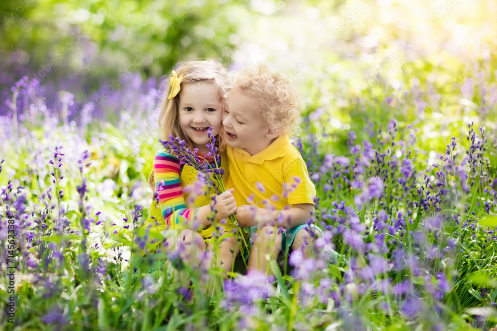 Kids playing in blooming garden with bluebell flowers