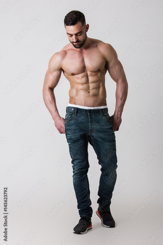 Muscle male model in jeans posing on white background. Studio shoot. Stock  Photo | Adobe Stock