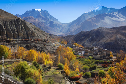 Thorong la Pass between two high hills with snow tops, and Muktinath valley with local nepalese buddhist village, in the autumn. Horizontal view, Nepal, Annapurna Circuit; Himalaya mountains; Asia © olmoroz
