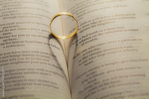 Wedding rings casting a heart shape on a book