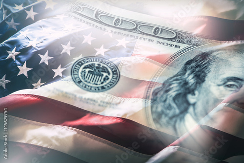 USA flag and American dollars. American flag blowing in the  wind and 100 dollars banknotes in the background.
