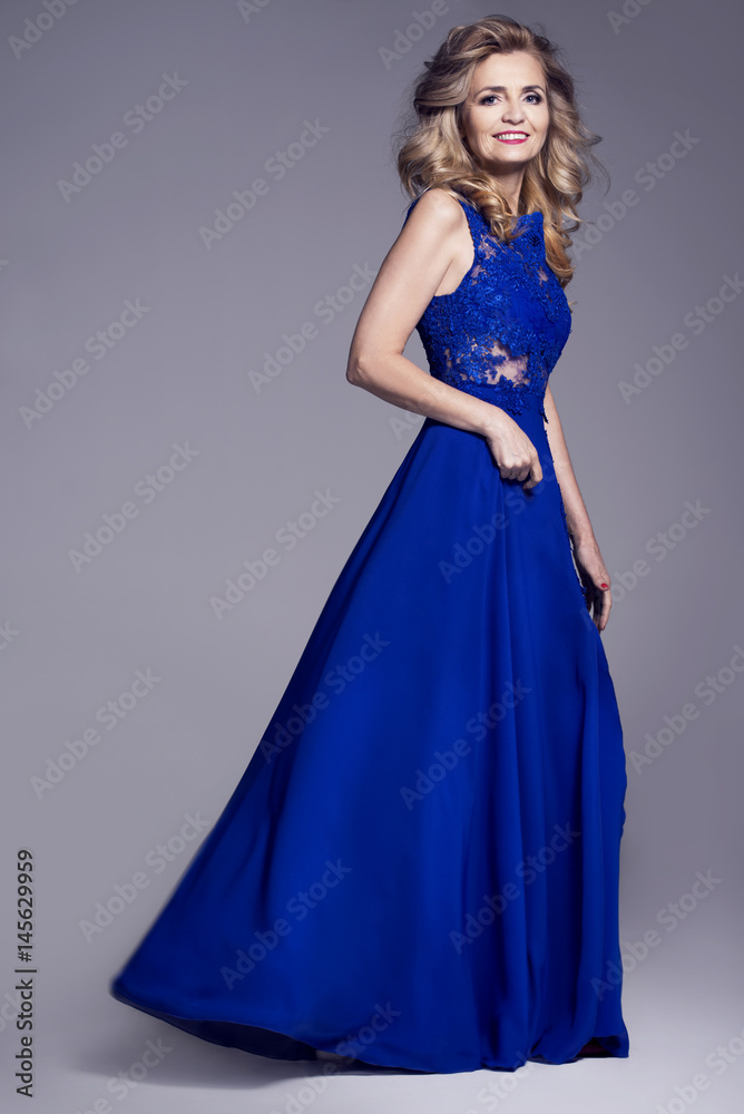 Beautiful older woman in an evening dress on a gray background Beautiful older woman in an evening dress on a gray background