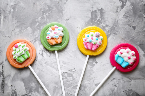 Tasty lollipops on grey textured background