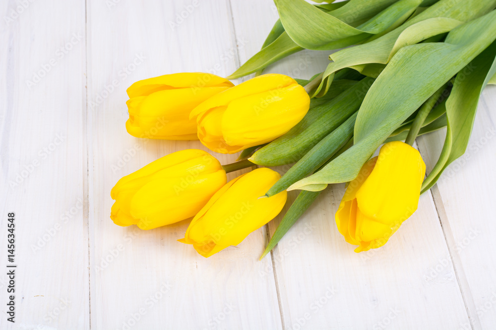 Obraz premium Żółte tulipany na białym tle drewnianych