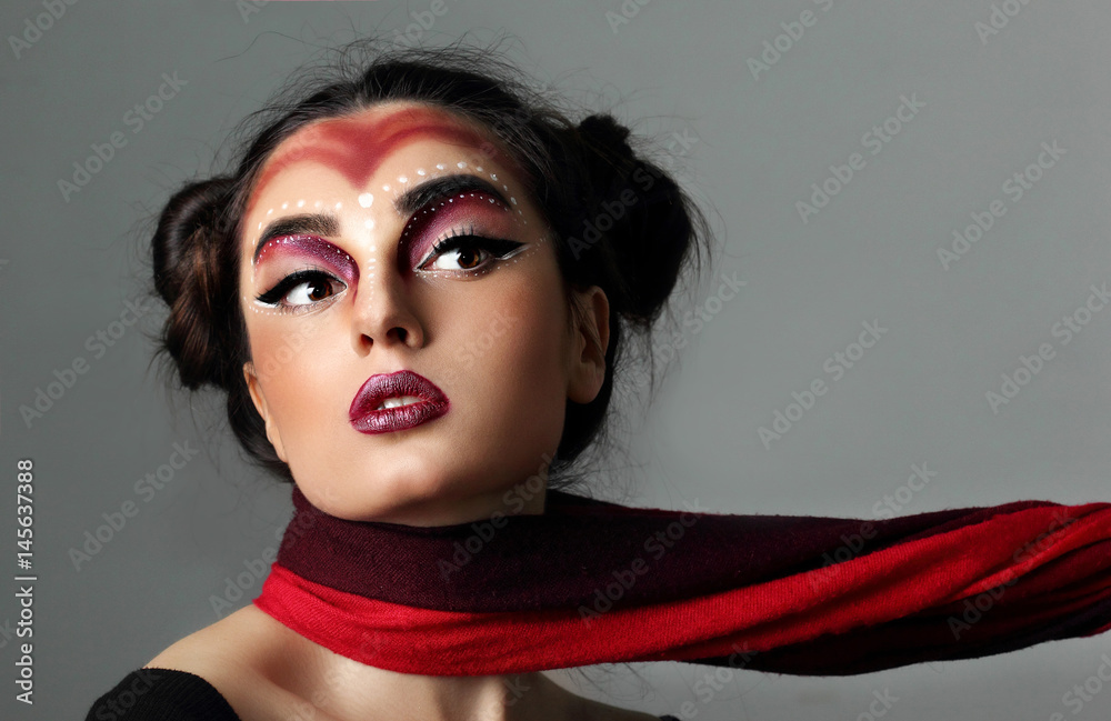 Pofrtrait fashion young model. Red and black sccarf on neck pull  model.Futuristic makeup art. Top knot hairdo.Perfect beaty  skin.closeup.Gray background Stock Photo | Adobe Stock