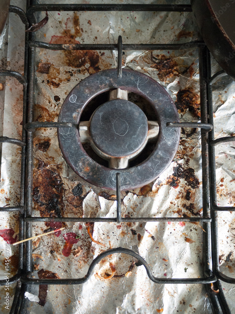 The Dirty and Grimy and Rusted Top of Gas Cooker Hob with Bits of Foil Underneath the Metal with Bits of Food and High Detaul Shining with Cracks and Blemishes and Stains Used for Cooking with Pan The Dirty and Grimy and Rusted Top of Gas Cooker Hob with Bits of Foil Underneath the Metal with Bits of Food and High Detaul Shining with Cracks and Blemishes and Stains Used for Cooking with Pan