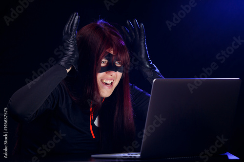 Surprised night hacker by laptop