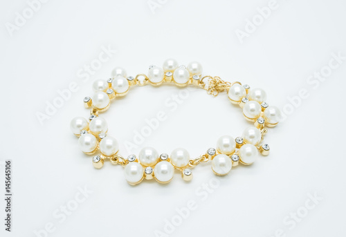 on a white background lies a pearl necklace on the neck and bracelet 