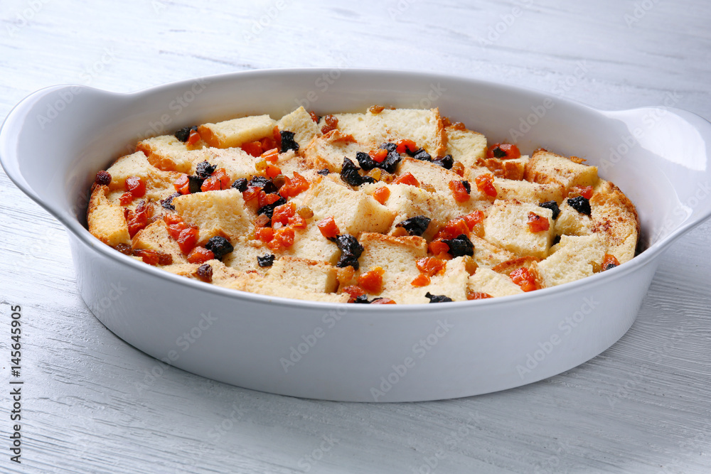 Freshly baked bread pudding in casserole dish on wooden table Freshly baked bread pudding in casserole dish on wooden table