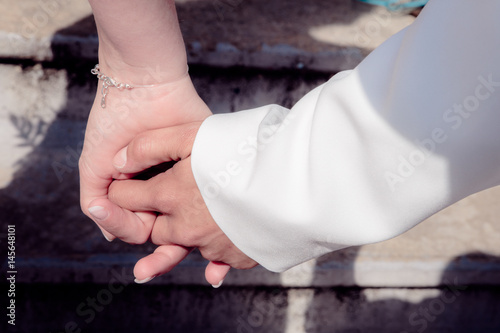 Bride and groom holding hands during wedding ceremony