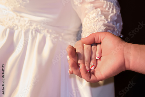 Bride and groom holding hands during wedding ceremony
